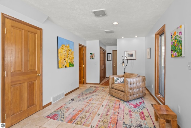 sitting room featuring light tile patterned flooring and a textured ceiling