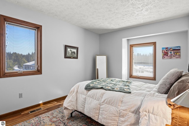 bedroom featuring hardwood / wood-style flooring and a textured ceiling