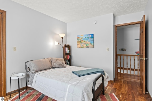 bedroom with dark wood-type flooring and a textured ceiling