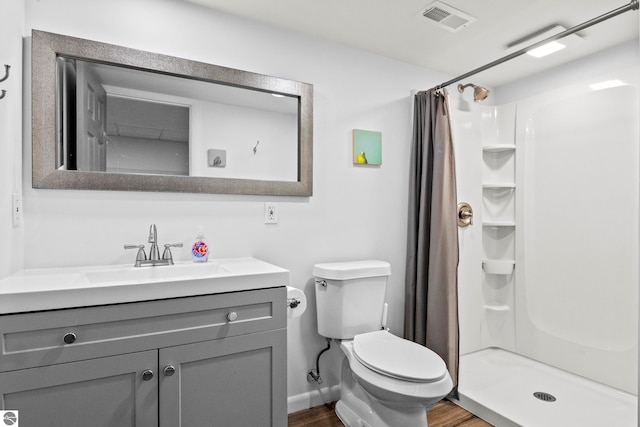 bathroom with toilet, wood-type flooring, vanity, and a shower with curtain