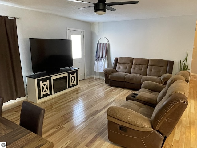 living room with light hardwood / wood-style flooring and ceiling fan