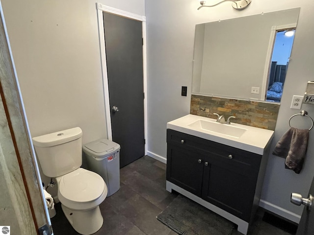 bathroom featuring vanity, backsplash, and toilet