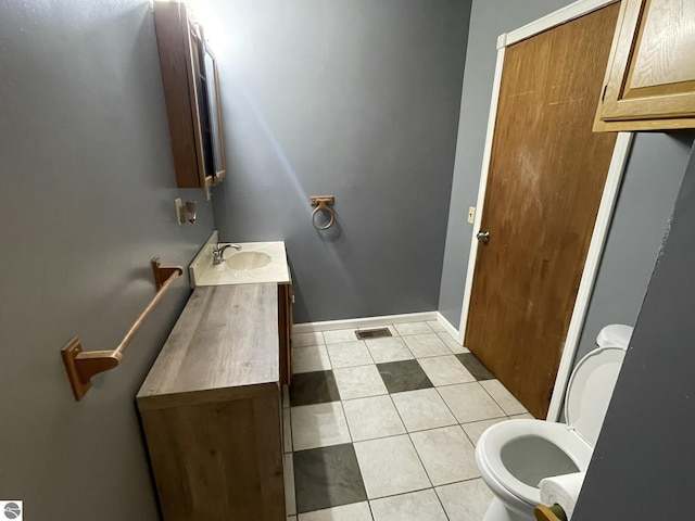 bathroom featuring tile patterned flooring, vanity, and toilet