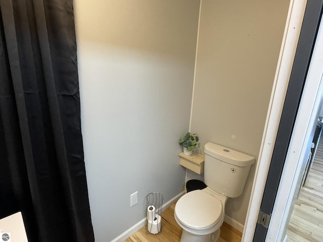 bathroom featuring hardwood / wood-style flooring and toilet