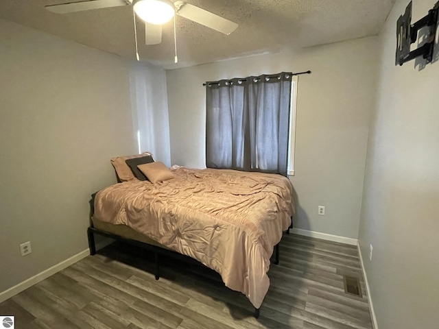 bedroom featuring ceiling fan, a textured ceiling, and dark hardwood / wood-style flooring