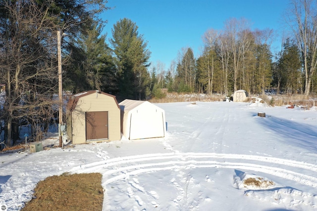 yard layered in snow with a storage shed