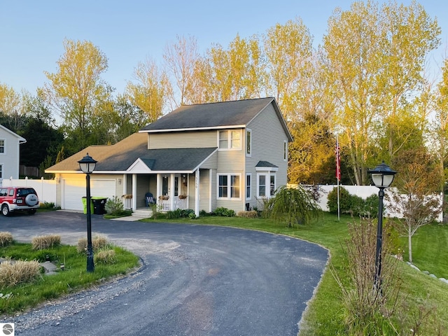 view of front of house featuring a garage, a front lawn, and a porch