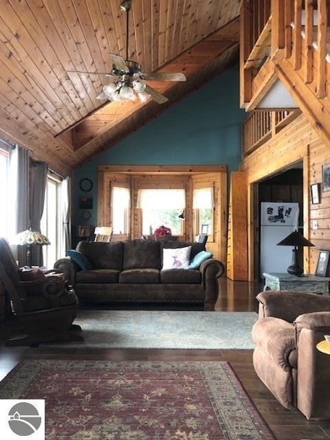 living room with lofted ceiling, hardwood / wood-style floors, wooden ceiling, and ceiling fan