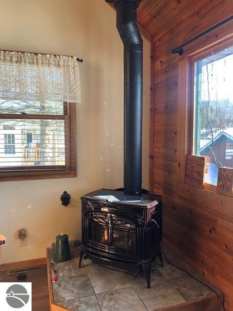 room details with wooden walls and a wood stove