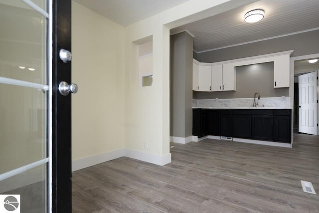 kitchen with white cabinetry, sink, and light hardwood / wood-style floors