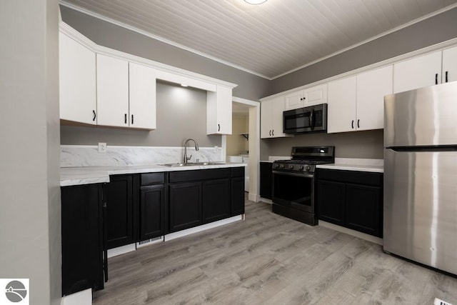 kitchen with sink, crown molding, white cabinetry, light hardwood / wood-style floors, and black appliances