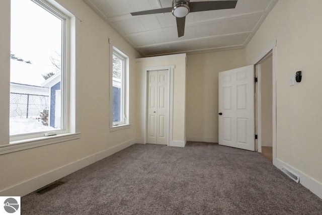 unfurnished bedroom featuring ceiling fan, a closet, and carpet