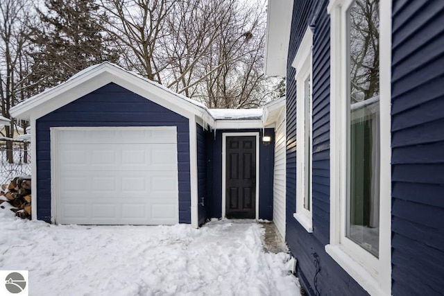 view of snow covered exterior featuring a garage