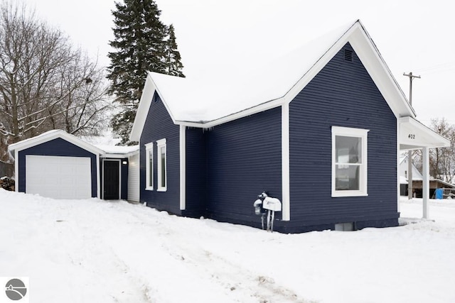 snow covered property with a garage