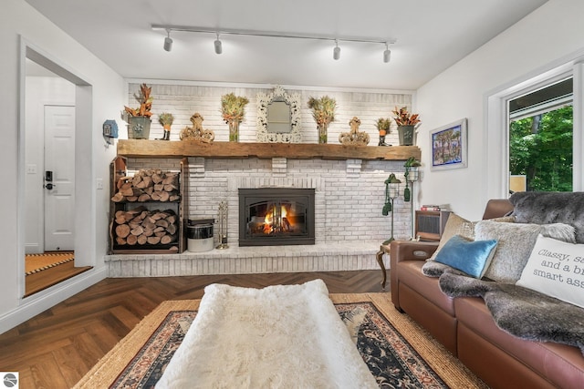 living room featuring a brick fireplace and dark parquet floors