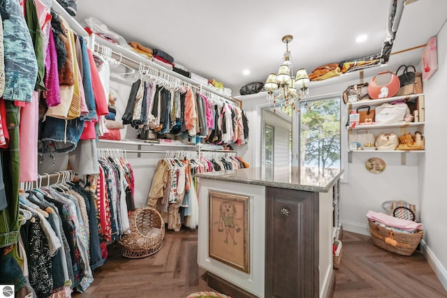 walk in closet featuring parquet flooring and a notable chandelier