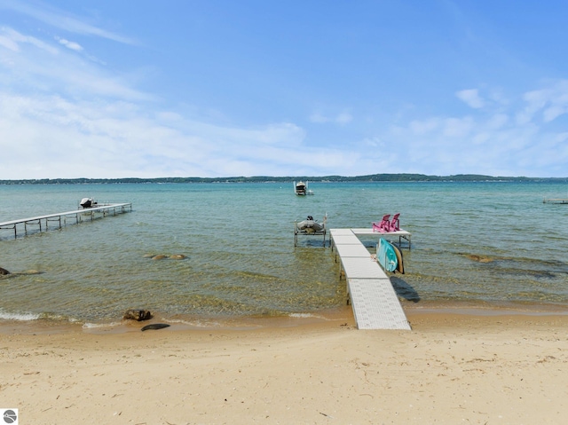 view of dock with a view of the beach and a water view