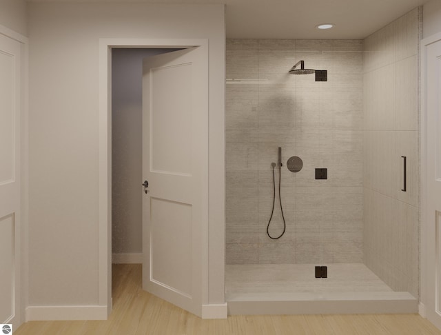 bathroom featuring a tile shower and wood-type flooring