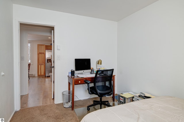 carpeted bedroom featuring baseboard heating and stainless steel refrigerator with ice dispenser