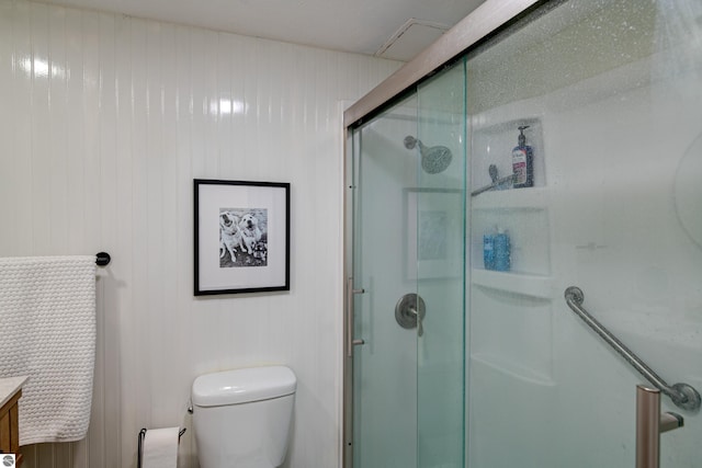 bathroom with vanity, toilet, and a shower with door