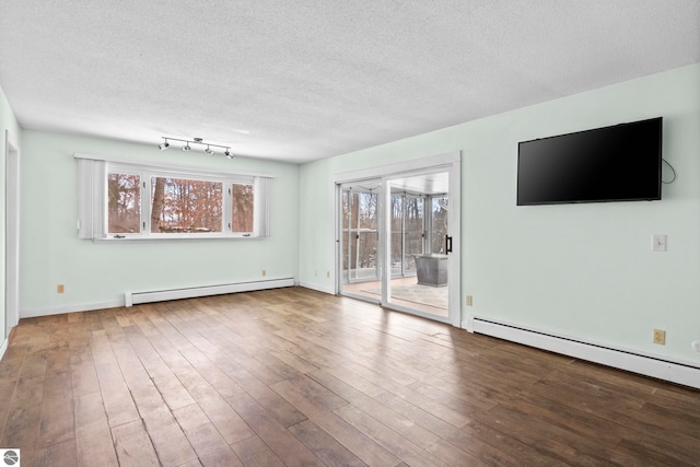 unfurnished living room featuring a baseboard radiator, wood-type flooring, and a textured ceiling