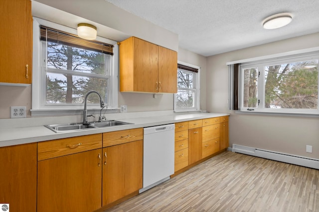 kitchen with dishwasher, sink, a textured ceiling, and baseboard heating