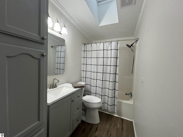 full bathroom with hardwood / wood-style floors, shower / bath combination with curtain, vanity, toilet, and a textured ceiling