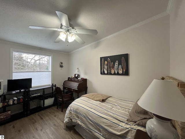 bedroom with hardwood / wood-style flooring, ceiling fan, ornamental molding, and a textured ceiling