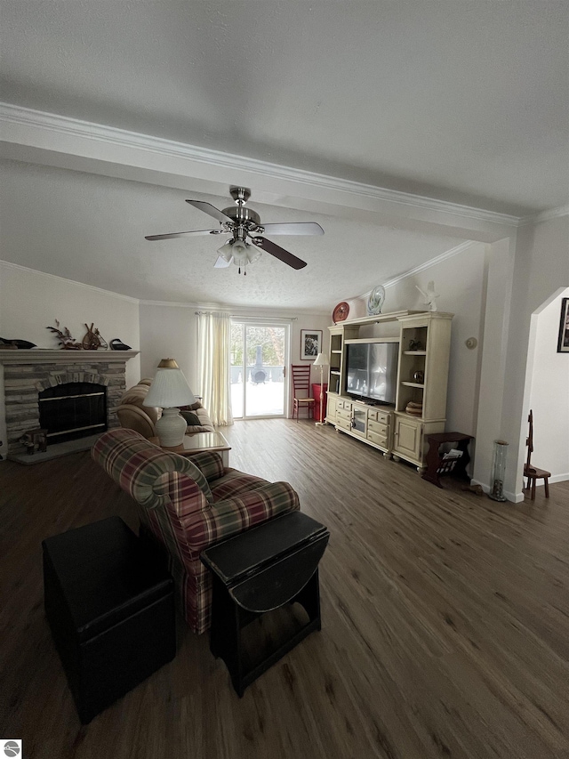 living room with ceiling fan, a fireplace, ornamental molding, and dark hardwood / wood-style floors