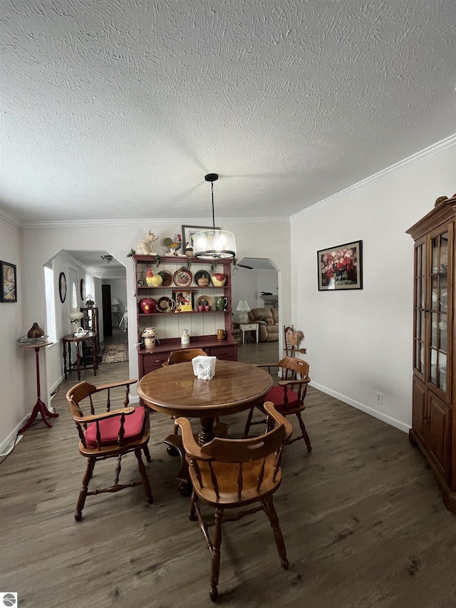 dining space featuring ornamental molding, dark hardwood / wood-style floors, and a textured ceiling