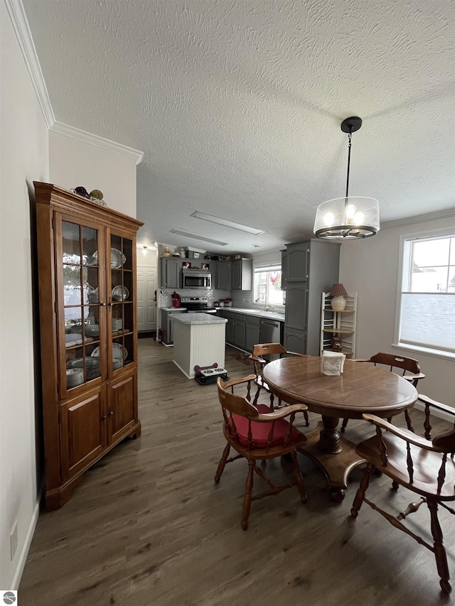 dining area with crown molding, dark hardwood / wood-style floors, and a textured ceiling