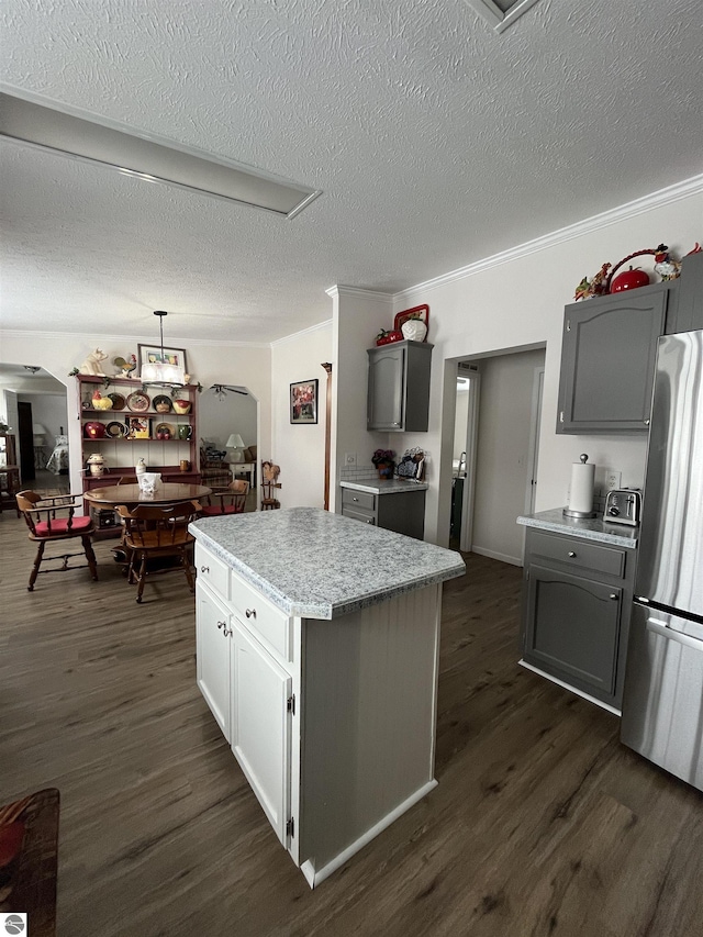 kitchen with gray cabinets, a center island, dark wood-type flooring, and stainless steel fridge