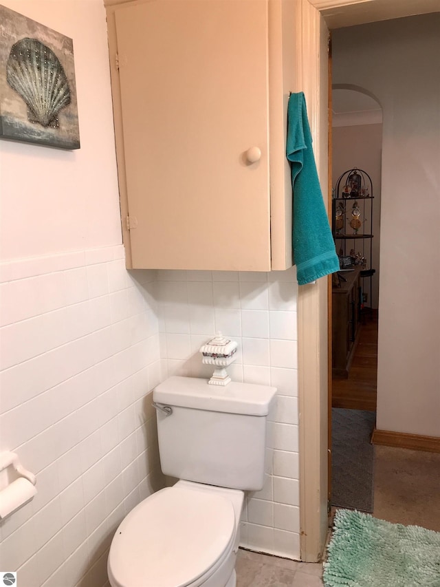 bathroom with tile walls and toilet