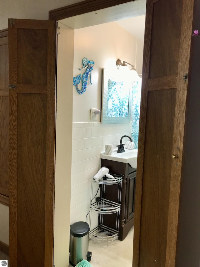 bathroom with vanity and tile walls