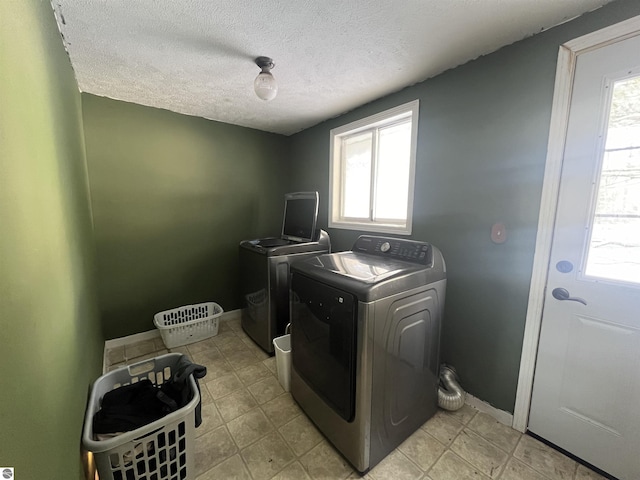 laundry room with washer and clothes dryer and a textured ceiling