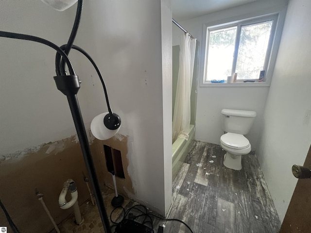 bathroom featuring hardwood / wood-style flooring, toilet, and shower / tub combo