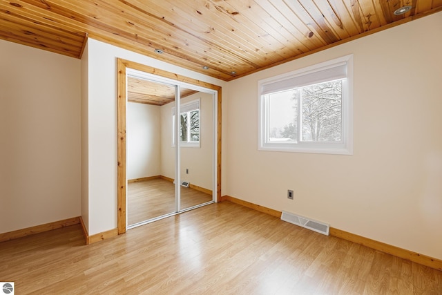 unfurnished bedroom featuring wooden ceiling, a closet, and light wood-type flooring