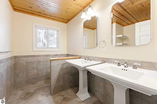 bathroom with double sink, tile walls, and wooden ceiling