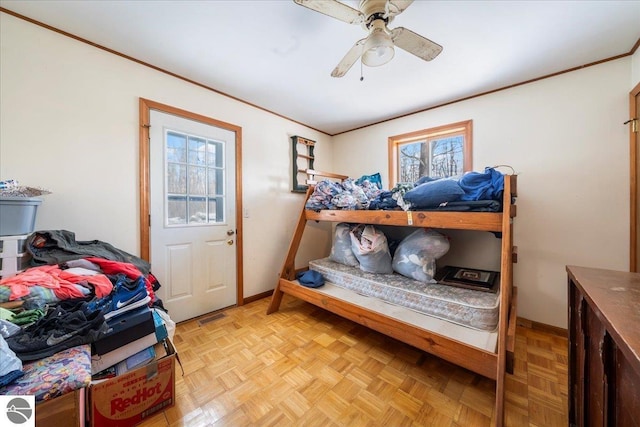 bedroom featuring light parquet flooring, ornamental molding, and ceiling fan