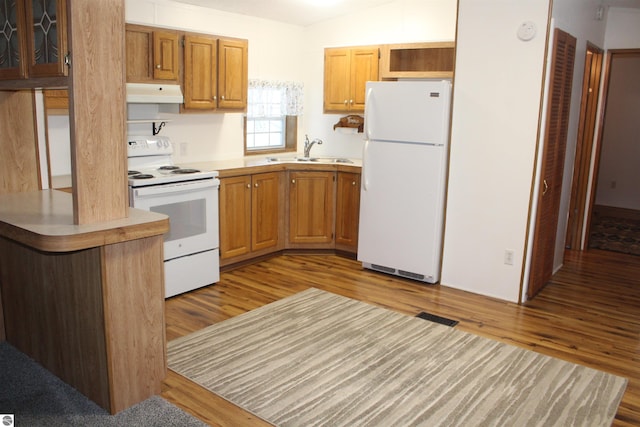 kitchen with sink, white appliances, and light wood-type flooring