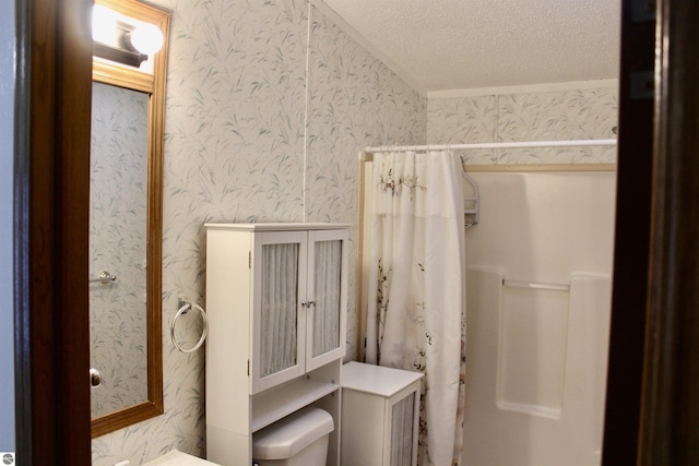 bathroom with a shower with curtain, toilet, and a textured ceiling