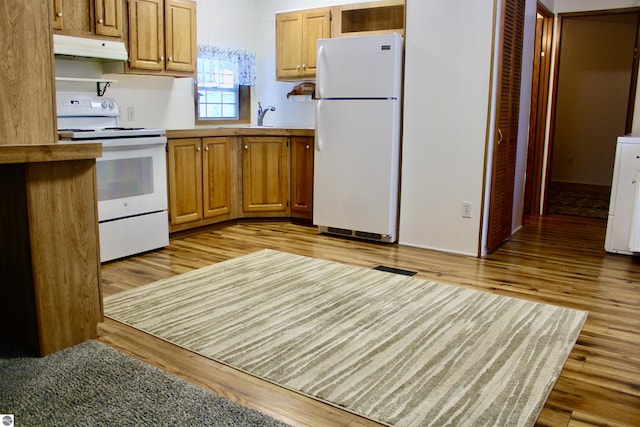 kitchen with sink, white appliances, and light wood-type flooring