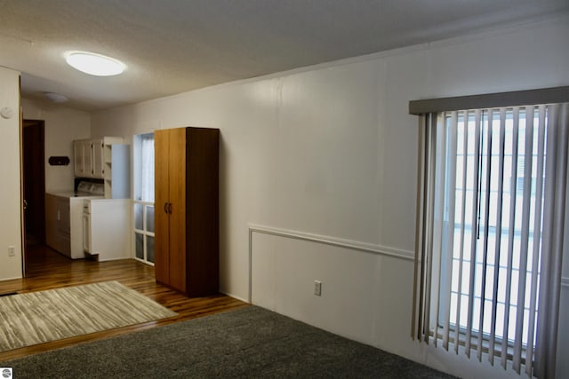 unfurnished room featuring dark carpet and washer and clothes dryer