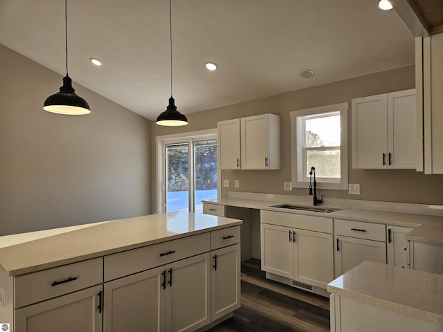 kitchen featuring white cabinetry, a healthy amount of sunlight, sink, and hanging light fixtures