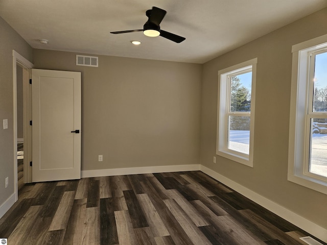 empty room with dark wood-type flooring and ceiling fan