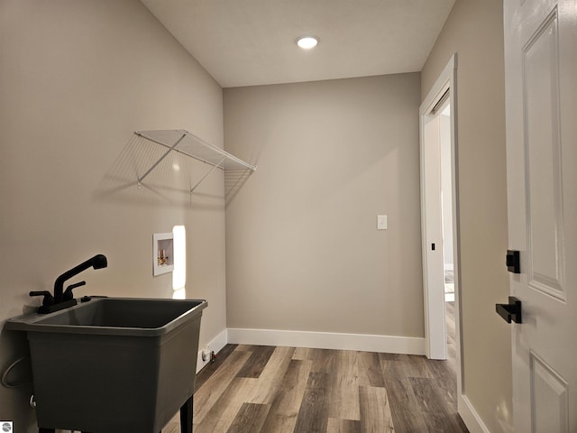 laundry area with washer hookup, hardwood / wood-style floors, and sink