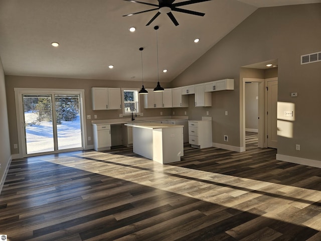 kitchen with white cabinetry, a center island, high vaulted ceiling, hanging light fixtures, and dark hardwood / wood-style floors