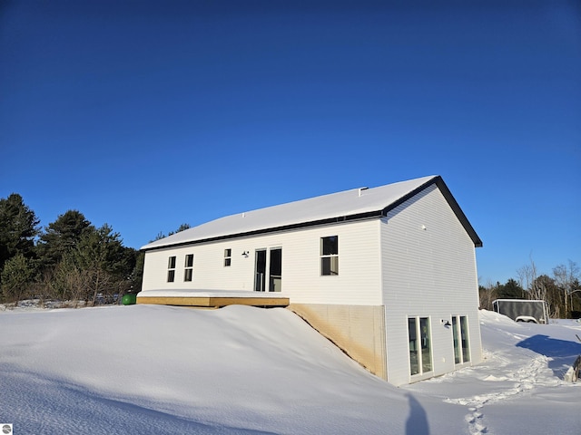 snow covered property with a deck