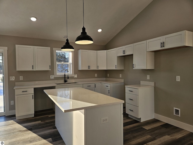 kitchen featuring white cabinetry, decorative light fixtures, sink, and a kitchen island