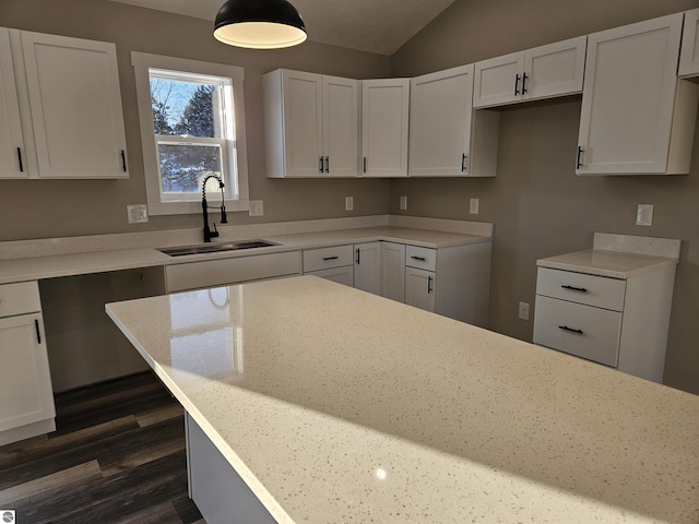 kitchen with sink, light stone counters, white cabinets, dark hardwood / wood-style flooring, and vaulted ceiling